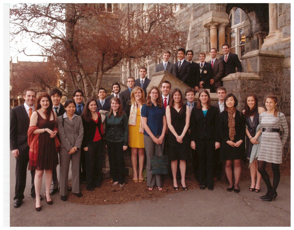 2009 Carroll Fellows, standing in front of Healy Hall in the fall, dressed in formal wear, smiling for the camera.