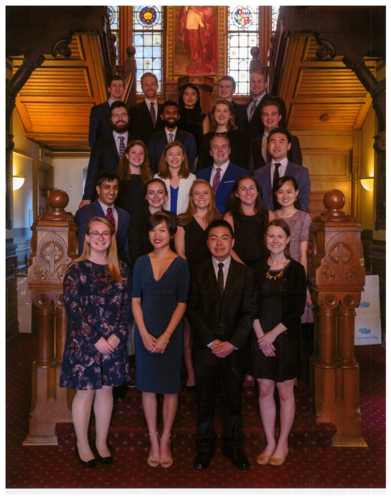 Carroll Fellows Class of 2018, standing in the lobby of Healy Hall, wearing formal clothing, smiling for the camera.