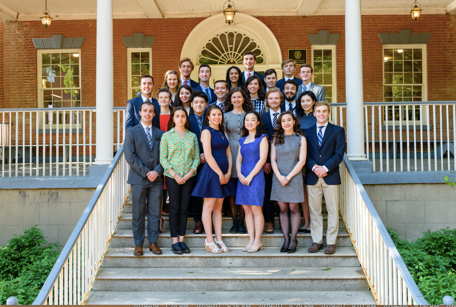 2019 Carroll Fellows, standing on the stairs in front of a building near Dalhgren Chapel, smiling for a formal photp.