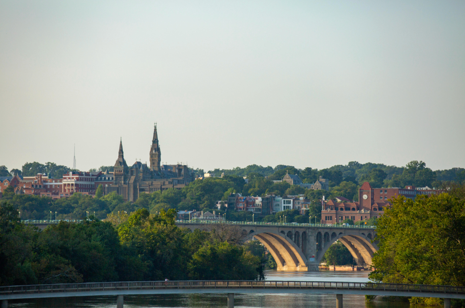 Landscape image of Key Bridge with Healy Hall in the background surrounded by green trees